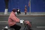 Trong những tháng gần đây, ĐCSTQ đã quảng bá mạnh mẽ “kinh nghiệm Phong Kiều,” các nhân viên an ninh quốc gia cũng đang hoạt động tích cực. Ảnh chụp một nhân viên ổn định xã hội đeo băng tay màu đỏ (bên kia đường) đang tuần tra trên đường phố Bắc Kinh. (Ảnh: Wang Zhao/AFP)