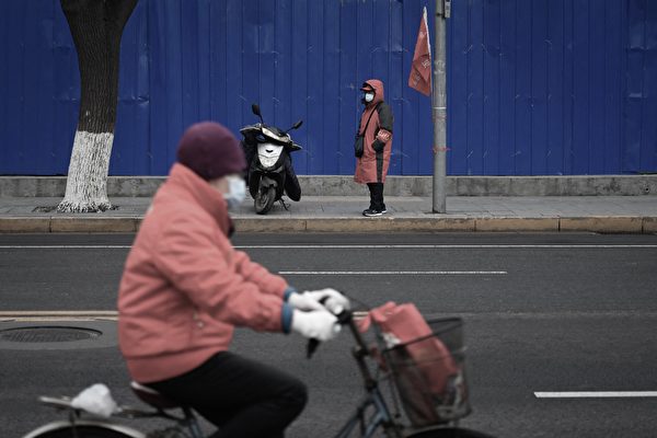 Trong những tháng gần đây, ĐCSTQ đã quảng bá mạnh mẽ “kinh nghiệm Phong Kiều,” các nhân viên an ninh quốc gia cũng đang hoạt động tích cực. Ảnh chụp một nhân viên ổn định xã hội đeo băng tay màu đỏ (bên kia đường) đang tuần tra trên đường phố Bắc Kinh. (Ảnh: Wang Zhao/AFP)