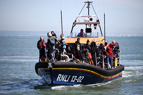Ngày 16/08/2023, tại bãi biển Dungeness, Anh quốc, nhiều người nhập cư từ Pháp đã rơi xuống biển khi cố gắng vượt eo biển Manche và được Viện cứu hộ quốc gia Hoàng gia (RNLI) giải cứu bằng xuồng cứu sinh. (Ảnh: Henry Nicholls/AFP)