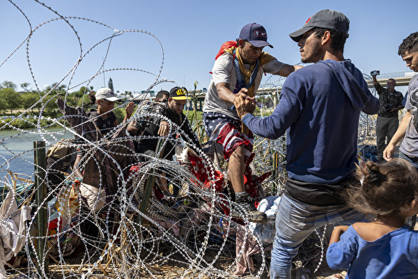 Ngày 28/09/2023, những người nhập cư từ Mexico đã vào Mỹ quốc sau khi vượt qua hàng rào thép gai ở Eagle Pass, Texas. (Ảnh: John Moore/Getty Images)