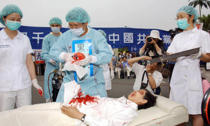 Các học viên Pháp Luân Công đang tái hiện lại thông lệ thu hoạch nội tạng cưỡng bức của ĐCSTQ đối với các học viên Pháp Luân Công, trong một cuộc mít-tinh ở Đài Bắc, Đài Loan, vào ngày 23/04/2006. (Ảnh: Patrick Lin/AFP qua Getty Images)