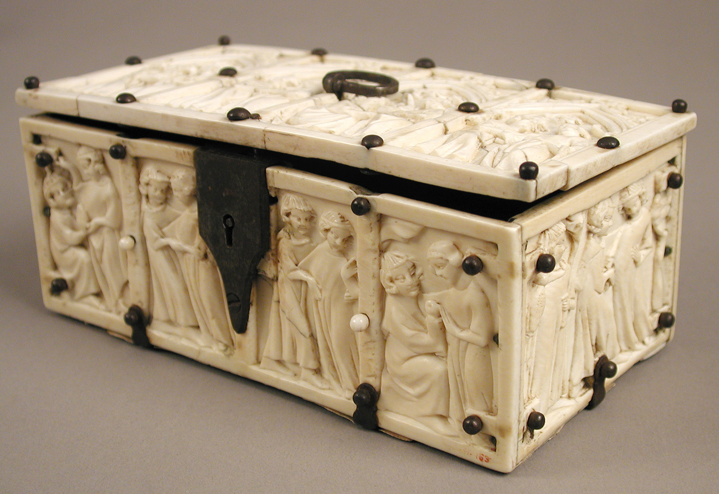 “Chiếc hộp khắc hình ảnh các đôi tình nhân” (Box with Courting Couples), thế kỷ thứ 14. Ngà voi kết hợp với các khung sắt hiện đại được bồi giấy bìa cứng; kích thước 70mm x 155mm x 90mm. Bảo tàng Nghệ thuật Metropolitan, New York. (Ảnh: Tài liệu công cộng)