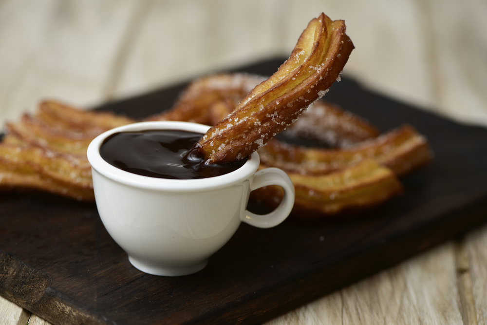 Món bánh Churro kèm sốt chocolate là món ăn nhẹ ngọt ngào đặc trưng của Tây Ban Nha. (Ảnh: Nito/Shutterstock)