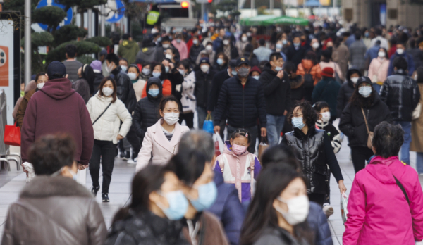 Những người đeo khẩu trang bảo hộ đi bộ trên đường Nam Kinh ở Thượng Hải vào ngày 11/12/2022. (Ảnh: Hu Chengwei/Getty Images)
