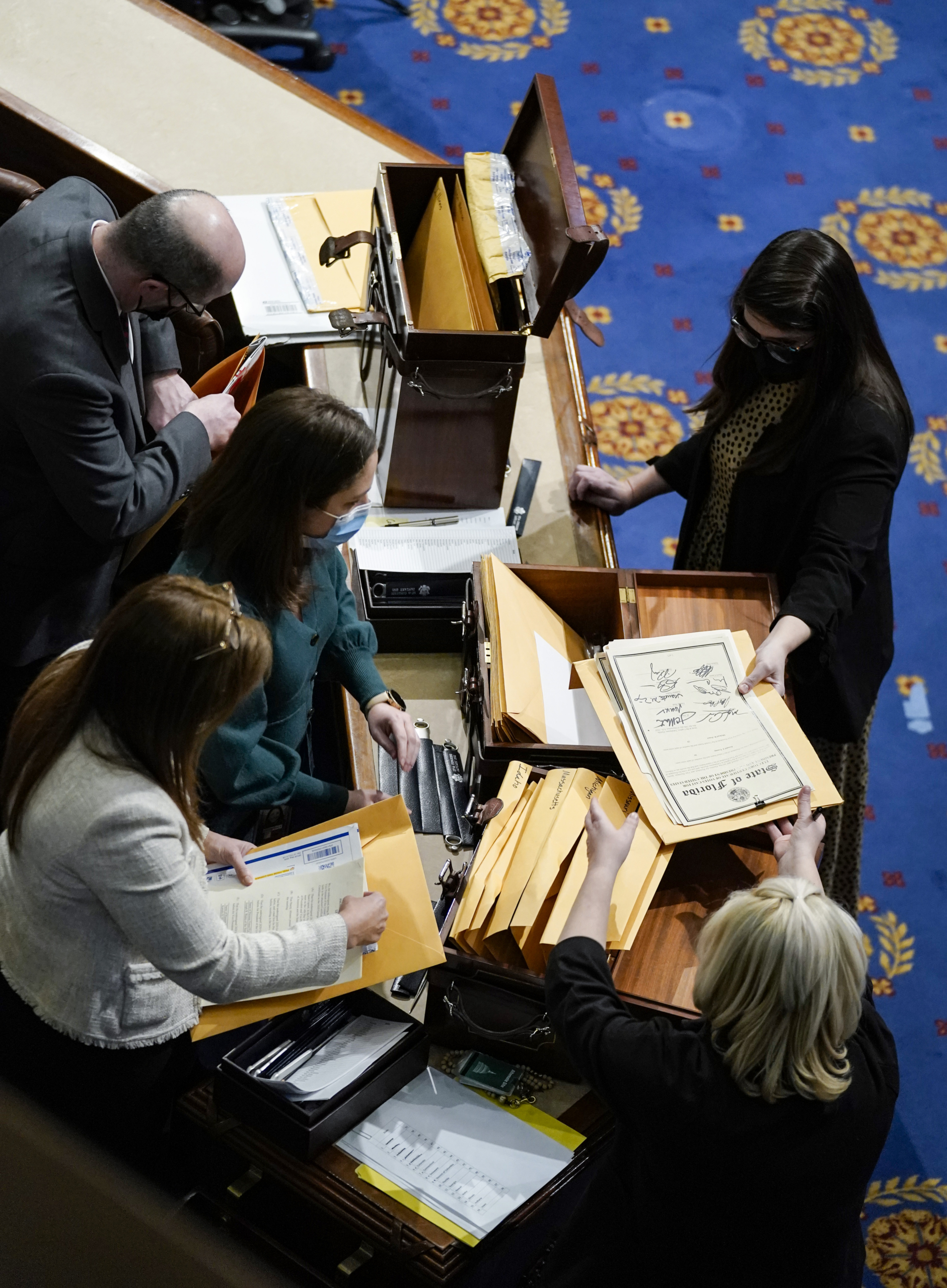 Các trợ lý ở Quốc hội kiểm tra phiếu đại cử tri đoàn tại Phòng Hạ viện trong một cuộc triệu tập lại của phiên họp chung của Quốc hội tại Hoa Thịnh Đốn, vào ngày 06/01/2021. (Ảnh: Drew Angerer/Getty Images)
