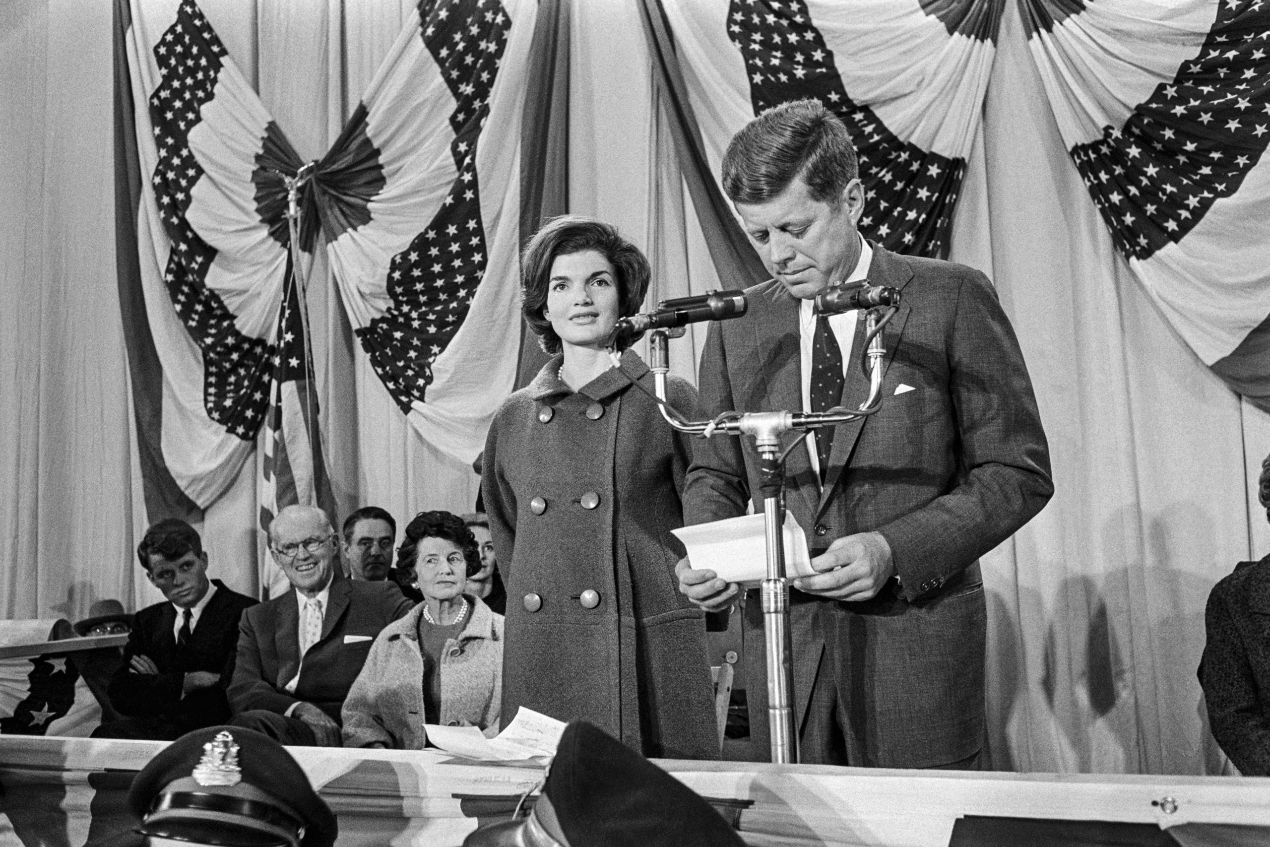 Tổng thống đắc cử John Fitzgerald Kennedy (bên phải), cùng Đệ nhất Phu nhân Jacqueline Kennedy, đọc bài diễn văn chiến thắng vào ngày 09/11/1960 tại Kho vũ khí Vệ binh Quốc gia ở Cảng Hyannis, Massachusetts, vào ngày 09/11/1960. (Ảnh: AFP qua Getty Images)