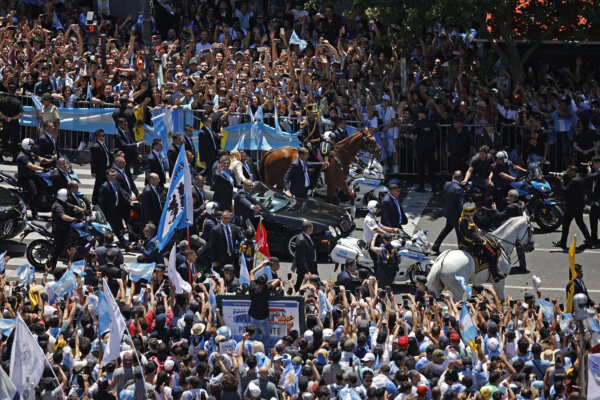 Tổng thống mới của Argentina, ông Javier Milei, cùng em gái Karina Milei, vẫy tay chào đám đông trên đường đến Dinh Tổng thống Casa Rosada trong một chiếc xe mui trần sau khi ông tuyên thệ nhậm chức trong lễ nhậm chức tại Quốc hội ở Buenos Aires hôm 10/12/2023. (Ảnh: Alejandro Pagni/AFP qua Getty Images)