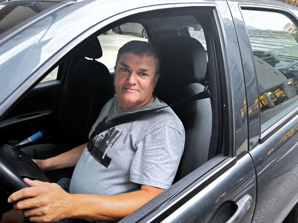 Ông Carlos Bastino, 58 tuổi, trong chiếc xe mà ông sử dụng để kiếm thêm thu nhập ở Buenos Aires, Argentina, hôm 09/12/2023. (Ảnh: Marcos Schotgues/The Epoch Times)