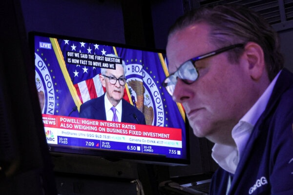 Một màn hình hiển thị cuộc họp báo của Chủ tịch Hội đồng Dự trữ Liên bang Jerome Powell sau thông báo về lãi suất của Fed khi một nhà giao dịch làm việc trên sàn của Sở Giao dịch Chứng khoán New York (NYSE) ở New York hôm 13/12/2023. (Ảnh: Brendan McDermid/Reuters)
