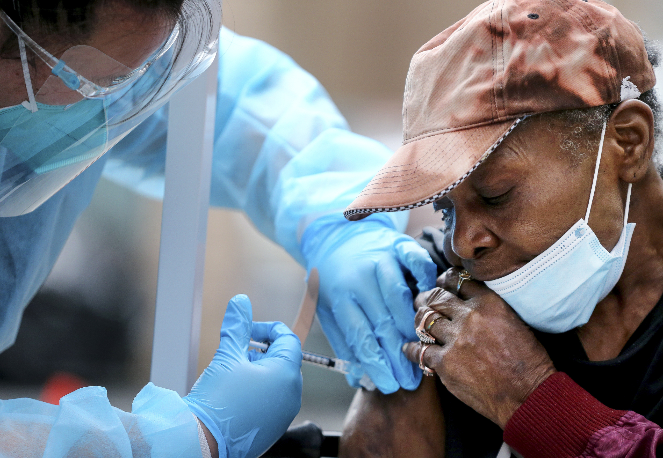 Bà Viola, 75 tuổi, được một nhân viên chăm sóc sức khỏe tại cộng đồng Skid Row ở Los Angeles chích cho một liều vaccine COVID-19 Moderna vào ngày 10/02/2021. (Ảnh: Mario Tama/Getty Images)