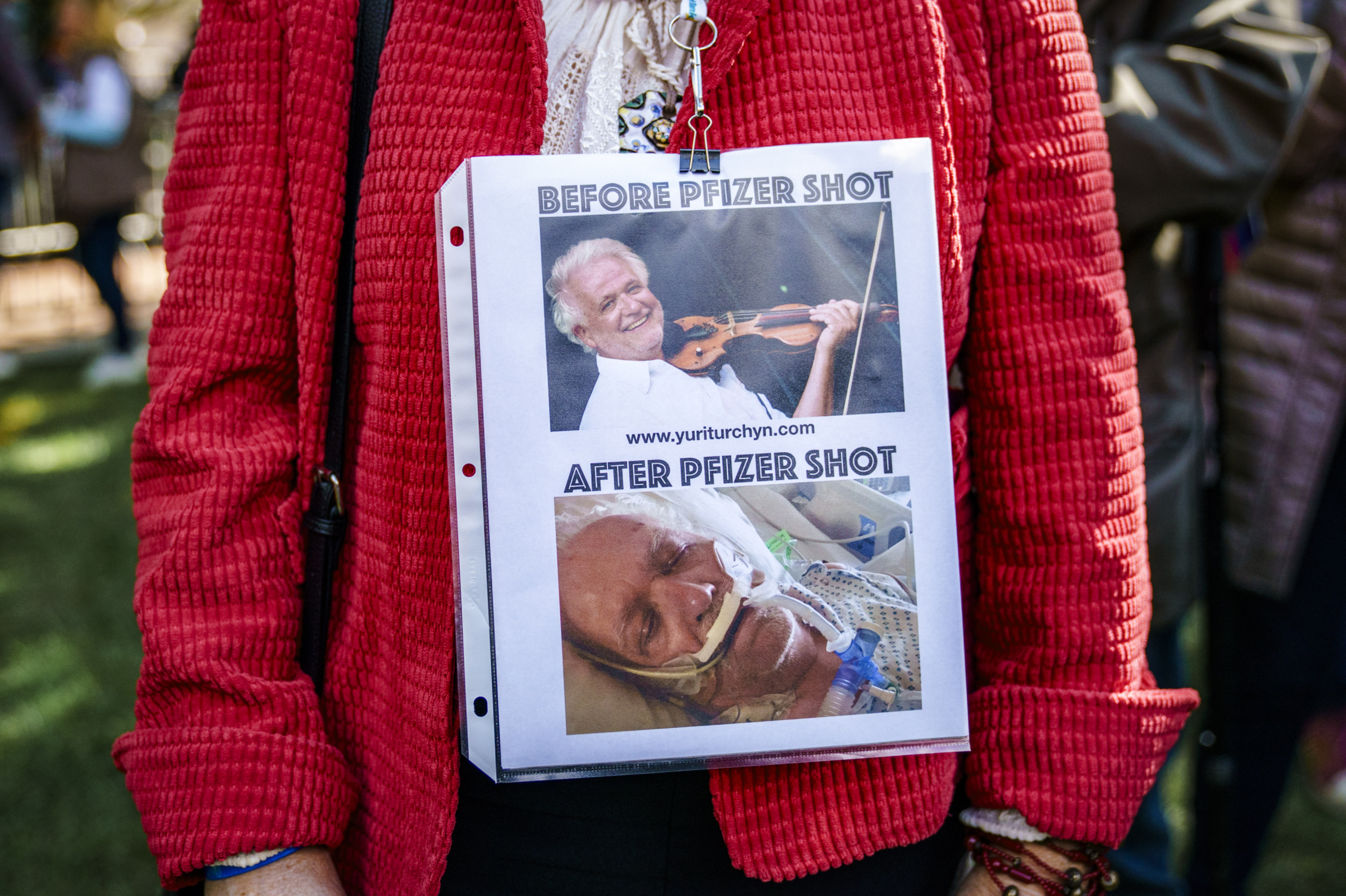 Một người phụ nữ trưng bày những bức ảnh của nghệ sĩ vĩ cầm Yury Turchyn trước và sau khi chích vaccine COVID-19, tại cuộc họp báo dành cho ứng cử viên tổng thống Robert F. Kennedy Jr. ở Philadelphia hôm 09/10/2023. (Ảnh: Jessica Kourkounis/Getty Images)