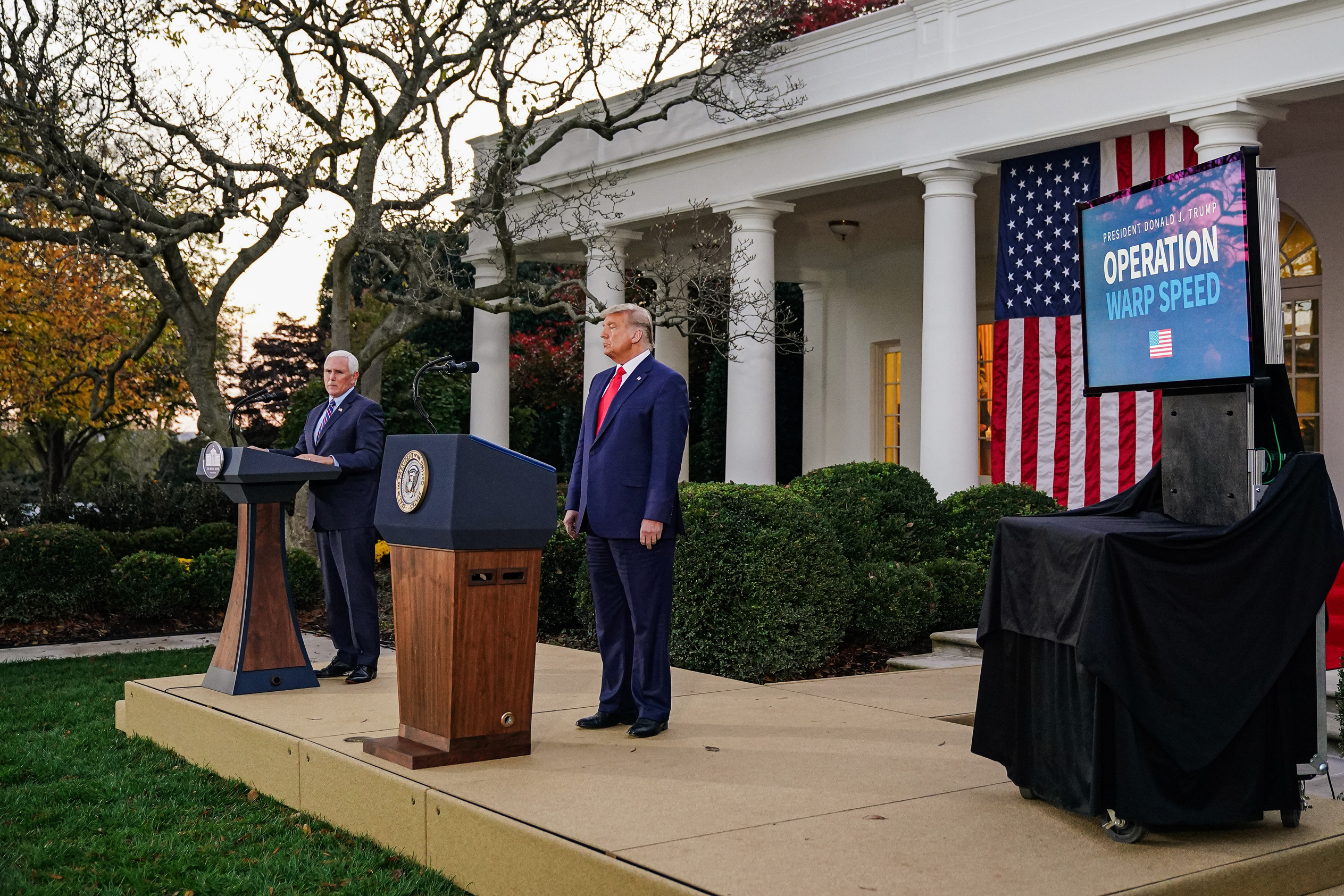 Phó Tổng thống Mike Pence khi đó (trái) và Tổng thống đương thời Donald Trump cung cấp thông tin cập nhật về Chiến dịch Thần tốc tại Vườn Hồng của Tòa Bạch Ốc vào ngày 13/11/2020. (Ảnh: Mandel Ngan/AFP qua Getty Images)