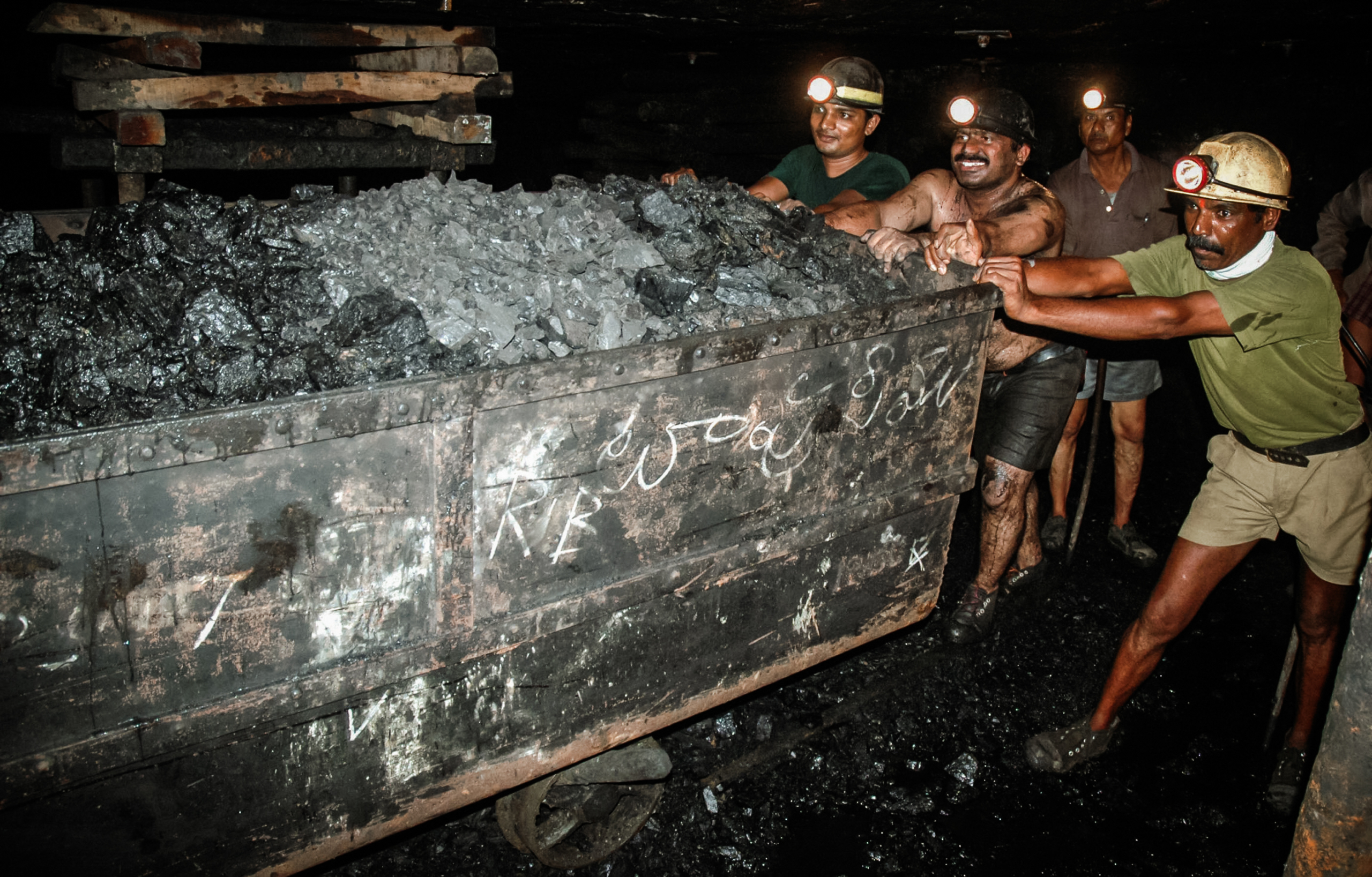 Thợ mỏ đẩy một xe chở đầy than bên trong đường hầm ngầm của một mỏ ở Godavarikhani, cách Hyderabad, Ấn Độ khoảng 150 dặm về phía đông, hôm 27/07/2007. (Ảnh: Noah Seelam/AFP qua Getty Images)