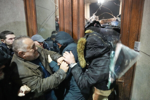 Người biểu tình cố gắng tiến vào tòa nhà hội đồng thành phố thủ đô ở Belgrade, Serbia, hôm 24/12/2023. (Ảnh: Darko Vojinovic/AP)