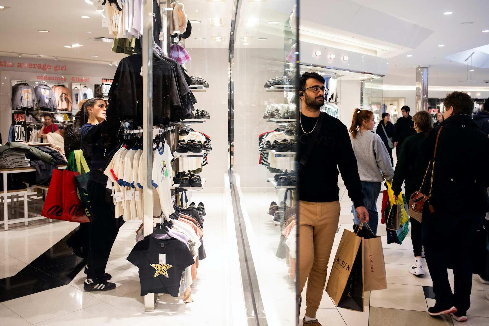 Khách mua hàng ngắm nhìn quần áo trong khi những người khác đi dạo quanh trung tâm thương mại Twelve Oaks ở Novi, Michigan, hôm 24/11/2023. (Ảnh: Emily Elconin/Getty Images)