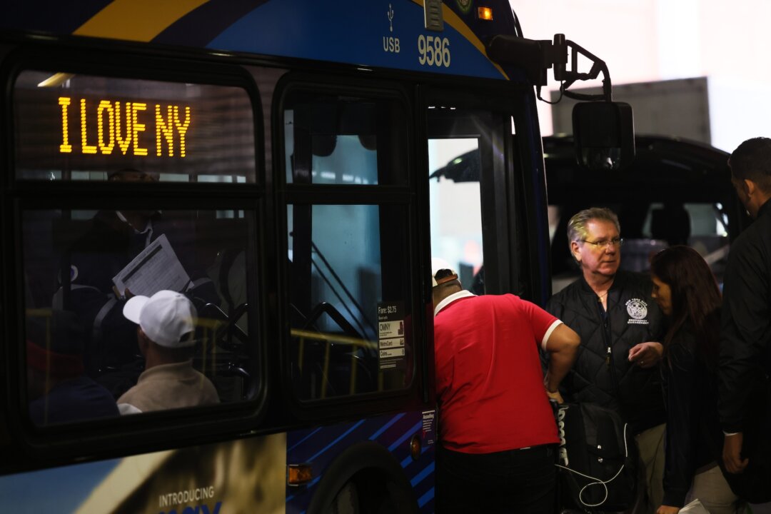 Những người nhập cư bất hợp pháp lên một chiếc xe bus đang trên đường đến nơi trú ẩn tại Bến xe bus Port Authority, ở thành phố New York hôm 18/05/2023. (Ảnh: Michael M. Santiago/Getty Images)