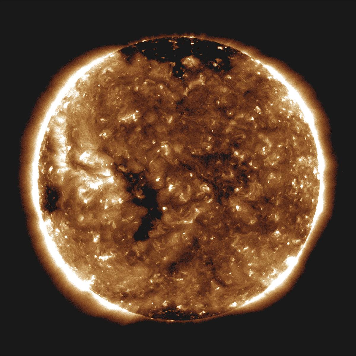 Tàu thăm dò mặt trời Parker của NASA đã quan sát thấy một cơn gió mặt trời chậm thoát ra ra từ lỗ vành nhỏ — một đốm đen dài và mỏng nhìn thấy ở phía bên trái của mặt trời trong hình ảnh này do Đài quan sát Động lực học Mặt trời của NASA chụp vào ngày 27 tháng 10 năm 2018. (NASA/ Tài liệu qua Reuters)