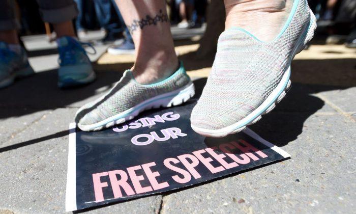 Một người phụ nữ dẫm lên tấm biểu ngữ về tự do ngôn luận tại Đại học California–Berkeley ở Berkeley, California, vào ngày 24/09/2017. (Ảnh: Josh Edelson/AFP/Getty Images)