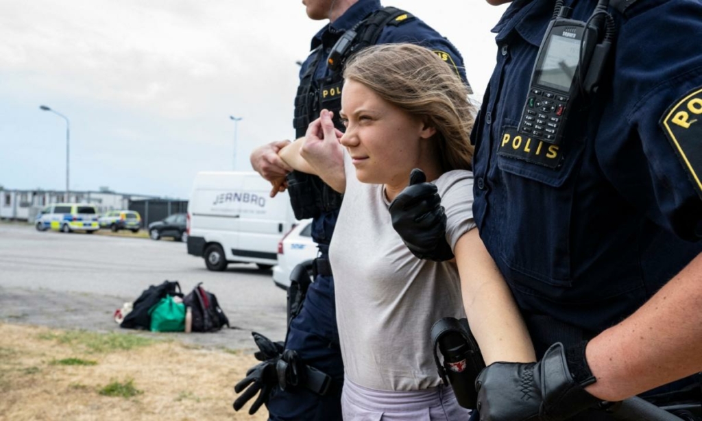 Cảnh sát áp giải nhà hoạt động khí hậu Thụy Điển Greta Thunberg cùng với các nhà hoạt động khí hậu khác từ tổ chức Ta Tillbaka Framtiden (Đòi lại Tương lai), khi những người này người chặn lối vào khu phố Oljehamnen ở Malmo, Thụy Điển, hôm 19/06/2023. (Ảnh: Johan Nilsson/TT News Agency/AFP qua Getty Images)