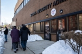 Một cặp vợ chồng lớn tuổi đi ngang qua Sở An sinh Xã hội ở Flushing, New York, trong đại dịch COVID-19 hôm 10/02/2021. (Ảnh: Chung I Ho/The Epoch Times)