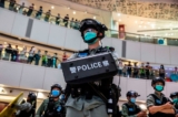 Một sĩ quan cảnh sát chống bạo động đứng bảo vệ trong một hoạt động giải tỏa cuộc biểu tình tại một trung tâm thương mại ở Hồng Kông vào ngày 06/07/2020. Cuộc biểu tình là sự phản ứng với luật an ninh quốc gia mới được ban hành tại thành phố, [luật này] đã biến các quan điểm chính trị, khẩu hiệu, và biển hiệu ủng hộ độc lập hay giải phóng Hồng Kông thành điều bất hợp pháp. (Ảnh: Isaac Lawrence/AFP via Getty Images)