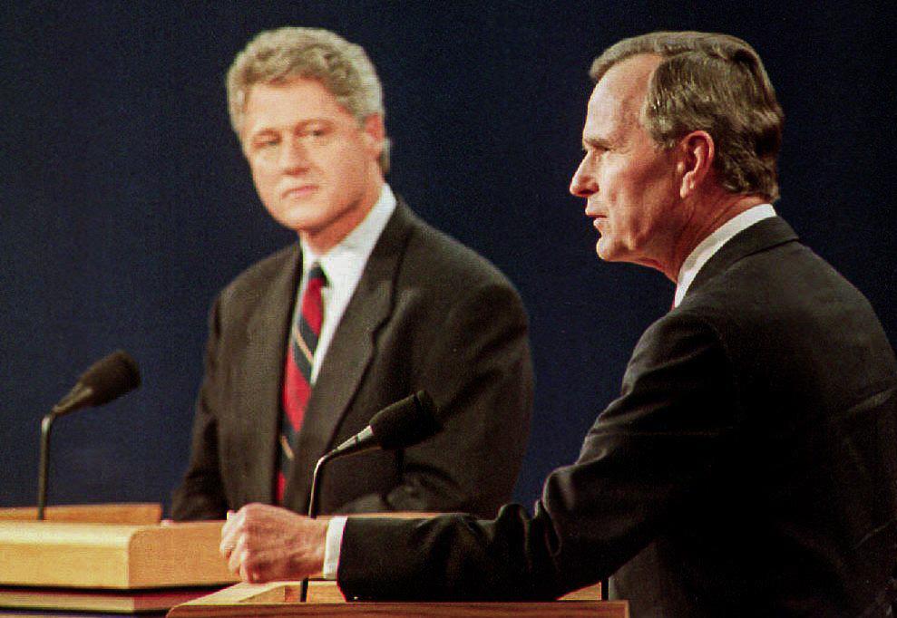 Tổng thống George Bush (phải) trả lời các câu hỏi khi ứng cử viên tổng thống của Đảng Dân Chủ Bill Clinton (trái) lắng nghe vào ngày 11/10/1992, tại St. Louis, Missouri. Hai ông, cùng với ứng cử viên độc lập Ross Perot, đang tham gia cuộc tranh biện đầu tiên của ba lần tranh biện tổng thống. (Ảnh: Eugene Garcia/AFP qua Getty Images)