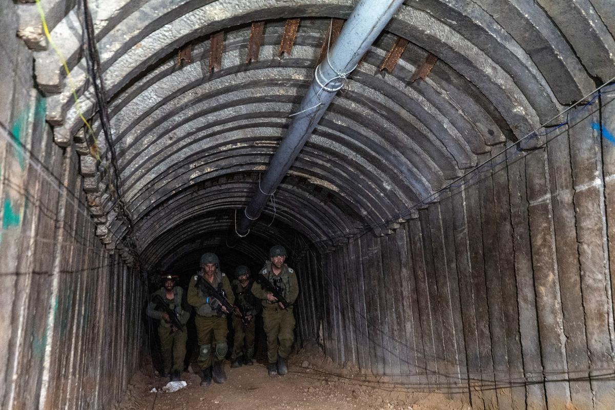 Binh lính Israel đi qua nơi mà quân đội Israel cho là một đường hầm có khung sắt do nhóm khủng bố Hamas thiết kế để tuồn các xe chở hàng của những kẻ khủng bố chuẩn bị cho một cuộc tấn công bất ngờ vào biên giới, gần cửa khẩu Erez ở phía bắc Dải Gaza, hôm 15/12/2023. (Ảnh: Amir Cohen/Reuters)