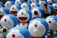 Một người đàn ông chụp ảnh bạn gái của mình tạo dáng bên cạnh nhân vật Doraemon trong một cuộc triển lãm ở Seoul, Nam Hàn, ngày 31/08/2015. (Ảnh: Kim Hong-Ji/Reuters)