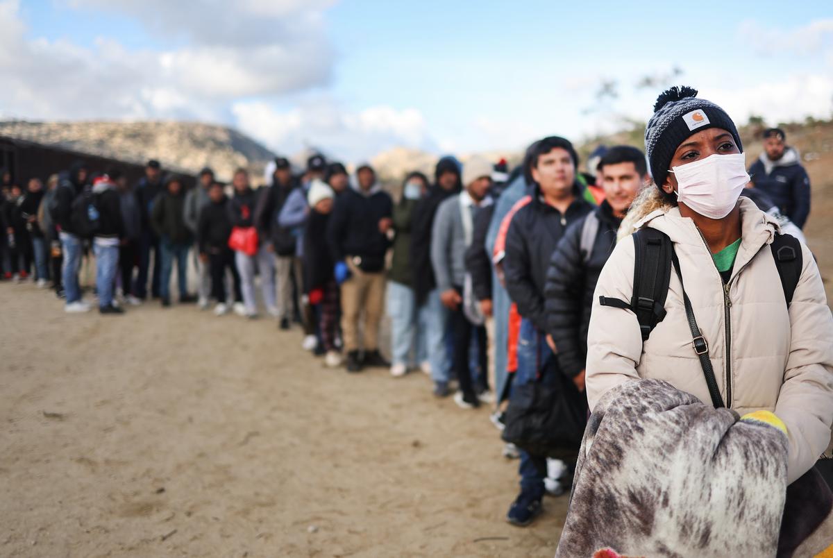 Những người di cư đang tìm kiếm tị nạn đứng tại một khu lán trại tạm thời dọc biên giới Hoa Kỳ-Mexico khi họ xếp hàng chờ lực lượng Tuần tra Biên giới Hoa Kỳ giải quyết ở Jacumba Hot Springs, California, hôm 01/12/2023. (Ảnh: Mario Tama/Getty Images)