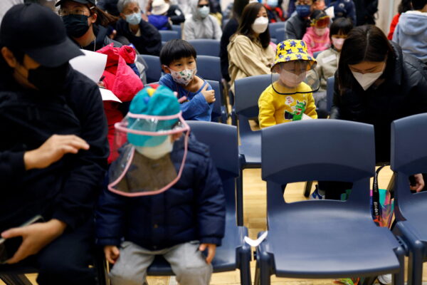Trẻ em nghỉ ngơi tại một trung tâm chích ngừa cộng đồng sau khi được chích một liều vaccine CoronaVac COVID-19 của Sinovac Biotech, sau đợt bùng phát COVID-19 ở Hồng Kông vào ngày 25/02/2022. (Ảnh: Tyrone Siu/Reuters)