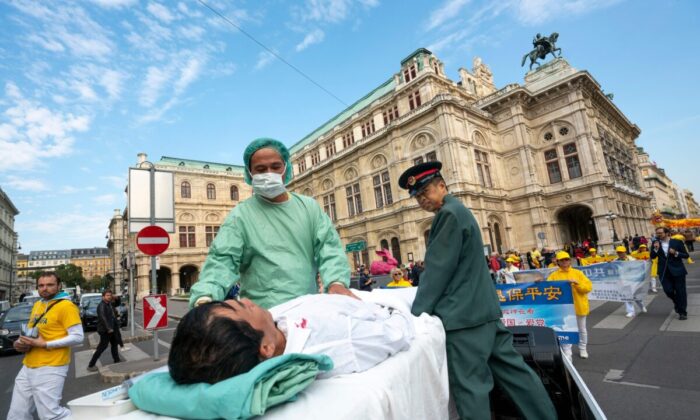Các học viên Pháp Luân Công tái hiện cảnh thu hoạch nội tạng từ các học viên bị cầm tù ở Trung Quốc trong cuộc biểu tình ở Vienna vào ngày 01/10/2018. (Ảnh: Joe Klamar/AFP qua Getty Images)