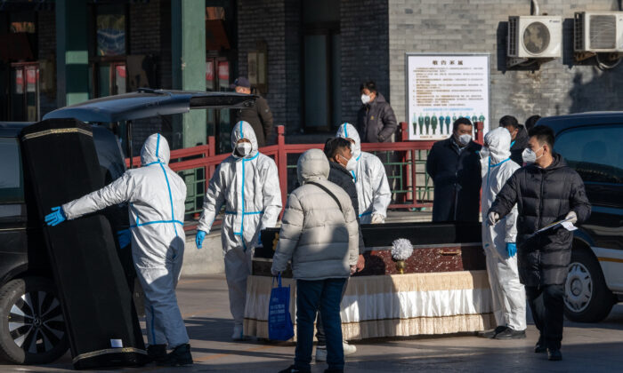 Các nhân viên mặc đồ bảo hộ khiêng quan tài tại Nhà tang lễ Đông Giao, một cơ sở được giao nhiệm vụ giải quyết các trường hợp tử vong do COVID-19, tại Bắc Kinh vào ngày 19/12/2022. (Ảnh: Bloomberg qua Getty Images)