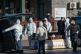 Nhân viên mặc đồ bảo hộ khiêng quan tài tại Nhà tang lễ Đông Giao, được cho là được giao nhiệm vụ giải quyết các trường hợp tử vong do COVID-19, tại Bắc Kinh vào ngày 19/12/2022. (Ảnh: Bloomberg qua Getty Images)
