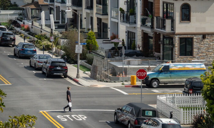 Một người đàn ông đi ngang qua các khu nhà ở ở Huntington Beach, California, hôm 17/03/2023. (Ảnh: John Fredricks/The Epoch Times)