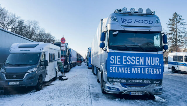 Khoảng 1,000 phương tiện di chuyển đã tập trung giữa Cột Chiến Thắng và Cổng Brandenburg để biểu tình. Chữ trên biểu ngữ “Quý vị chỉ có thức ăn chừng nào chúng tôi còn giao hàng” (Sie essen nur solange wir liefern). (Ảnh: Matthias Kehrein/Epoch Times)