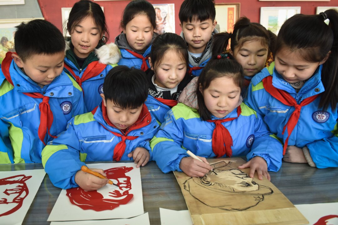 Các học sinh cắt giấy hình chân dung của cố lãnh đạo Đảng Cộng sản Trung Quốc Mao Trạch Đông trước ngày kỷ niệm sinh nhật lần thứ 127 của ông rơi vào ngày 26/12, tại Liên Vân Cảng, tỉnh Giang Tô, miền đông Trung Quốc vào ngày 23/12/2020. (Ảnh: STR/AFP qua Getty Images)