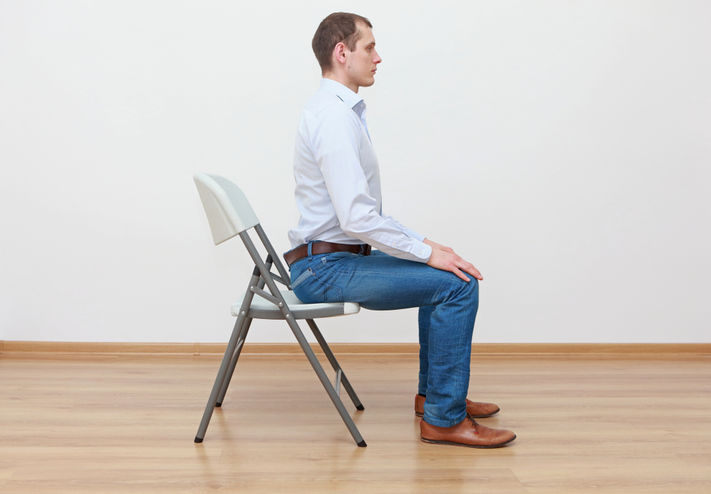 Tư thế ngồi kéo giãn cơ lưng. (Ảnh: Marcin Balcerzak/Shutterstock)