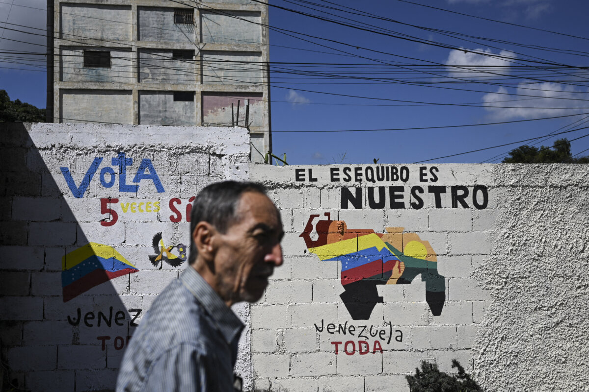Một người đàn ông đi ngang qua bức tranh tường vận động cho một cuộc trưng cầu dân ý đề nghị người dân Venezuela xem xét việc sáp nhập vùng Essequibo do Guyana quản lý ở Caracas, Venezuela, hôm 28 /11/2023. (Ảnh: Federico Parra/AFP qua Getty Images)