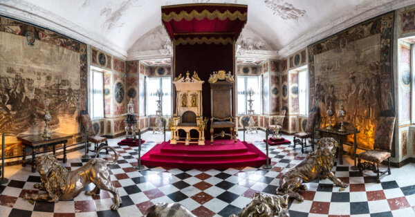 Phòng ngai vàng, do họa sĩ Tân cổ điển Đan Mạch kiêm giáo sư tại Học viện Nghệ thuật Hoàng gia Đan Mạch thiết kế, vẫn còn nguyên vẹn như ngày nào. Căn phòng này tỏa sáng với những gam màu mạnh mẽ và sự đối xứng nghiêm ngặt. Ở phía trái người xem, ngôi báu đăng quang chạm khắc tinh xảo được bao quanh bởi ba con sư tử bạc, sàn ô vuông bằng đá cẩm thạch, và những tấm thảm dệt lộng lẫy kể về những trận chiến giữa Đan Mạch và Thụy Điển. (Ảnh: Sergii Figurnyi/Shutterstock)
