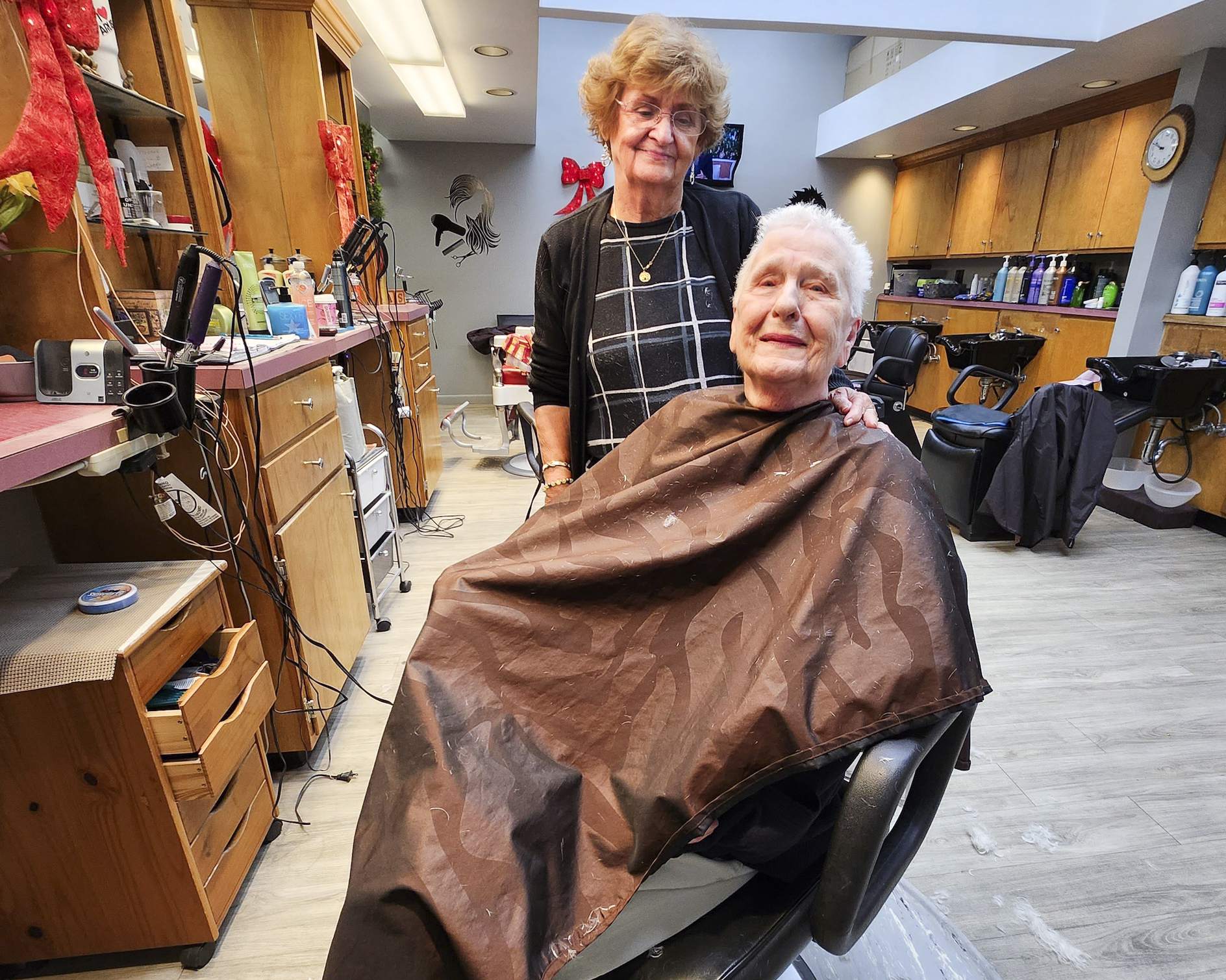 Bà Patricia Wescom, (trái) một nhà tạo mẫu tóc ở Barre, Vermont, và khách hàng Janice Boudreau của bà thảo luận về chính trị và năm sắp đến, hôm 12/12/2023. (Ảnh: Allan Stein/The Epoch Times)