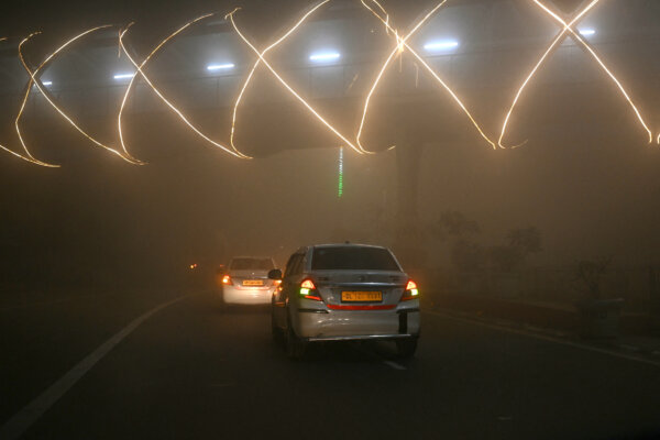Xe cộ di chuyển trong khói mù dày đặc vào một buổi sáng mùa đông lạnh giá ở New Delhi, Ấn Độ, hôm 27/12/2023. (Ảnh: Arun Sankar/AFP)