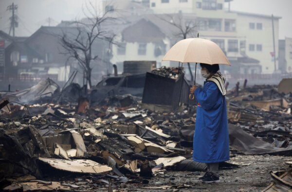 Một người phụ nữ đang nhìn khu chợ bị cháy rụi sau một trận động đất ở Wajima, tỉnh Ishikawa, Nhật Bản, hôm 03/01/2024. (Ảnh: Kyodo News qua AP)