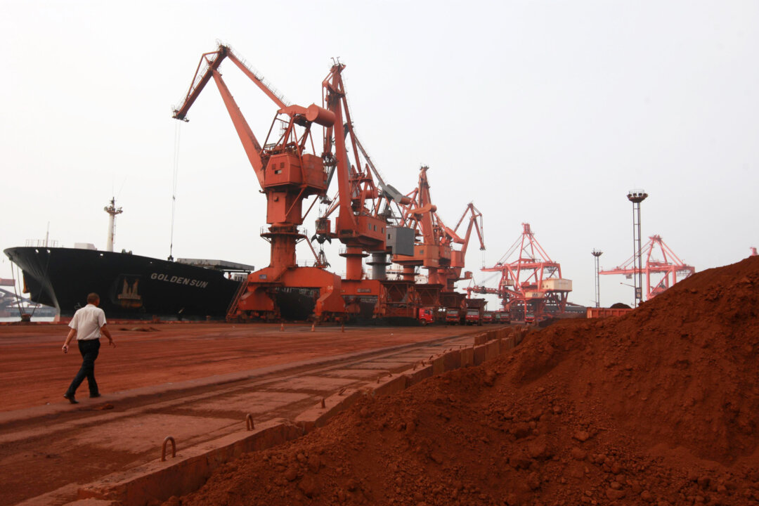 Máy ủi đang xúc đất tại một khu đất chứa nhiều loại đất hiếm và chất lên tàu tại Liên Vân Cảng, tỉnh Giang Tô, phía đông Trung Quốc, vào ngày 05/09/2010. (Ảnh: STR/AFP qua Getty Images)