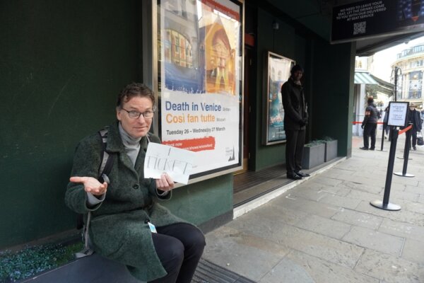 Ông Michael, một giáo viên ở California đến tham quan thành phố Oxford, ngồi trước cổng chính của Nhà hát New Theatre Oxford để chờ nhận được một tấm vé cho buổi biểu diễn hôm 06/01/2024. (Ảnh: Mary Mann/The Epoch Times)