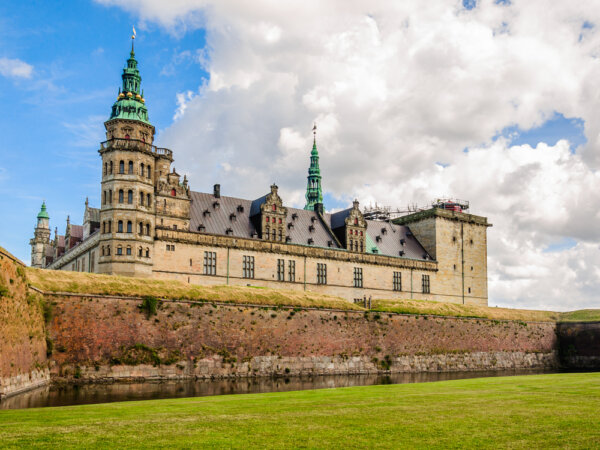 Được biết đến với tên gọi Lâu đài Elsinore trong vở kịch “Hamlet” của Shakespeare, Lâu đài Kronborg vẫn còn các dấu tích của kiến trúc nguyên gốc bên trong các công sự rộng lớn của lâu đài này. Những bức tường gạch và một con hào bao quanh công trình bằng đá sa thạch trắng với các trục cửa sổ bất đối xứng và trên cùng là những ngọn tháp kiểu Baroque màu rêu xanh. (Ảnh: Andrey Shcherbukhin/Shutterstock)