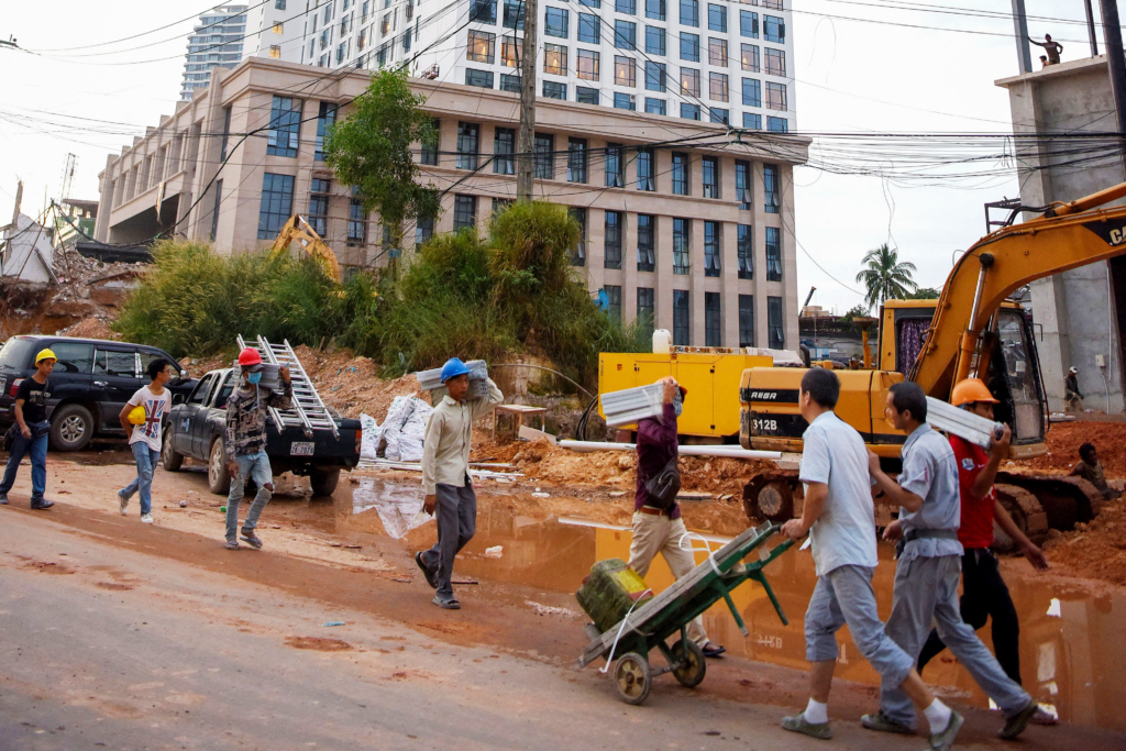 Công nhân Campuchia và Trung Quốc mang vật liệu đến một công trường xây dựng ở Sihanoukville, thủ phủ ven biển của tỉnh Preah Sihanouk, Campuchia, ngày 13/12/2018. (Ảnh: Tang Chhin Sothy/AFP qua Getty Images)