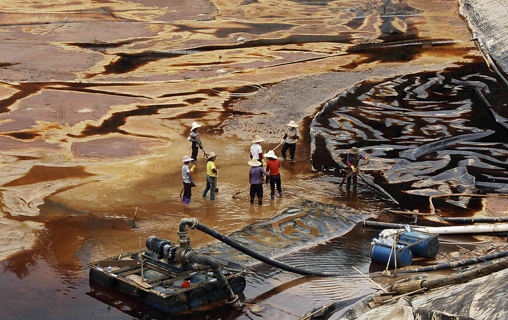 Công nhân khơi thoát nước bị ô nhiễm gần mỏ đồng của Tập đoàn Khai thác Khoáng sản Tử Kim (Zijin Mining Group) ở Thượng Hàng hôm 13/07/2010. Tử Kim đang mua 15% cổ phần công ty phát triển khoáng sản trọng yếu Solaris Resources Inc. của Canada với giá 130 triệu USD thông qua phát hành riêng lẻ hôm 11/01/2024 (Ảnh: STR/AFP qua Getty Images)