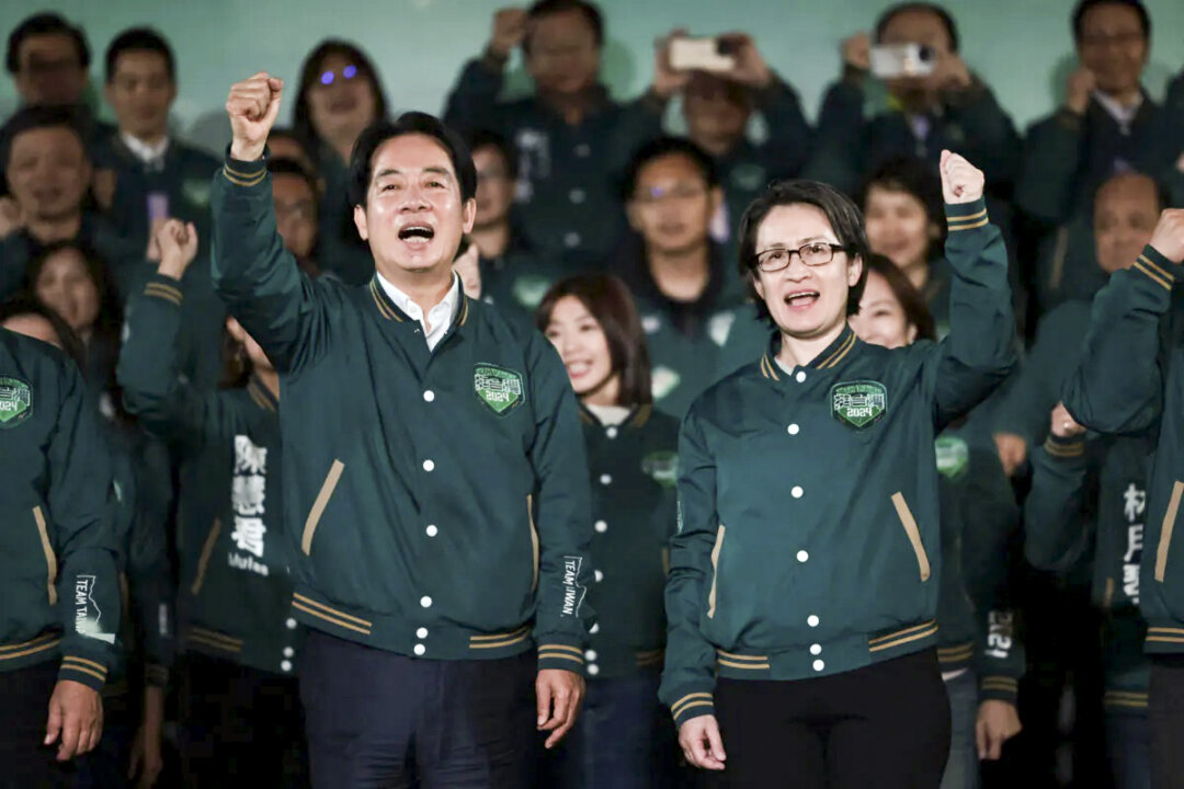 Ông Lại Thanh Đức (Lai Ching-te), Tổng thống đắc cử Đài Loan, làm cử chỉ giơ nắm tay bên cạnh người đồng tranh cử Tiêu Mỹ Cầm (Hsiao Bi-khim) trong một cuộc mít-tinh bên ngoài trụ sở của Đảng Dân Chủ Tiến Bộ (gọi tắt là Đảng Dân Tiến, DPP) ở Đài Bắc hôm 13/01/2024. (Ảnh: Yasuyoshi Chiba/AFP qua Getty Images)
