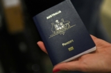 Một du khách xuất trình sổ thông hành (passport) Úc tại Phi trường Quốc tế Los Angeles ở Los Angeles, California, vào ngày 01/11/2021. (Ảnh: Patrick T. Fallon/AFP qua Getty Images)