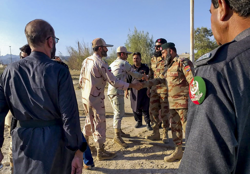 Trong bức ảnh này chụp vào ngày 21/04/2019, các quan chức an ninh biên giới Pakistan (phải) và các quan chức an ninh biên giới Iran (trái) bắt tay nhau tại Cột mốc số 0 (Zero Point) ở thị trấn Taftan nằm ở khu vực biên giới giữa Pakistan và Iran. Iran và Pakistan đã đồng ý thành lập một “lực lượng phản ứng” liên hợp ở biên giới sau một số cuộc tấn công thảm khốc của các nhóm phiến quân ở biên giới của họ, Tổng thống Iran Hassan Rouhani tuyên bố ngày 22/04 sau cuộc hội đàm với Thủ tướng Pakistan Imran Khan đang có chuyến thăm đến quốc gia này. (Ảnh: STR/AFP qua Getty Images)